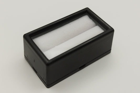 Black rectangular plastic box with white bifurcated pad and top window (5,2 * 2,8 * 2 cm)