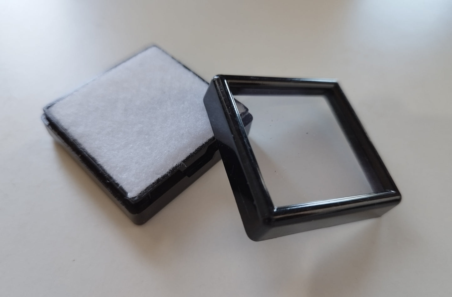 Black square plastic box with window and white pad (4 * 4 * 1,5 cm)