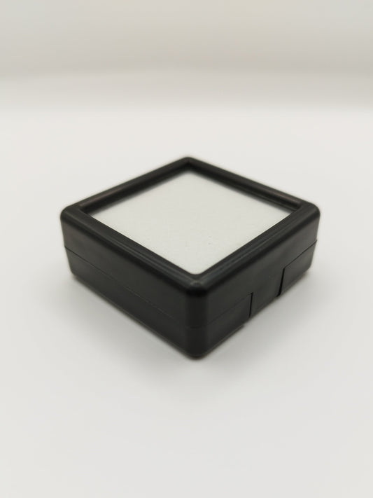 Black plastic box with window and white pad (4* 4 * 1,7 cm)