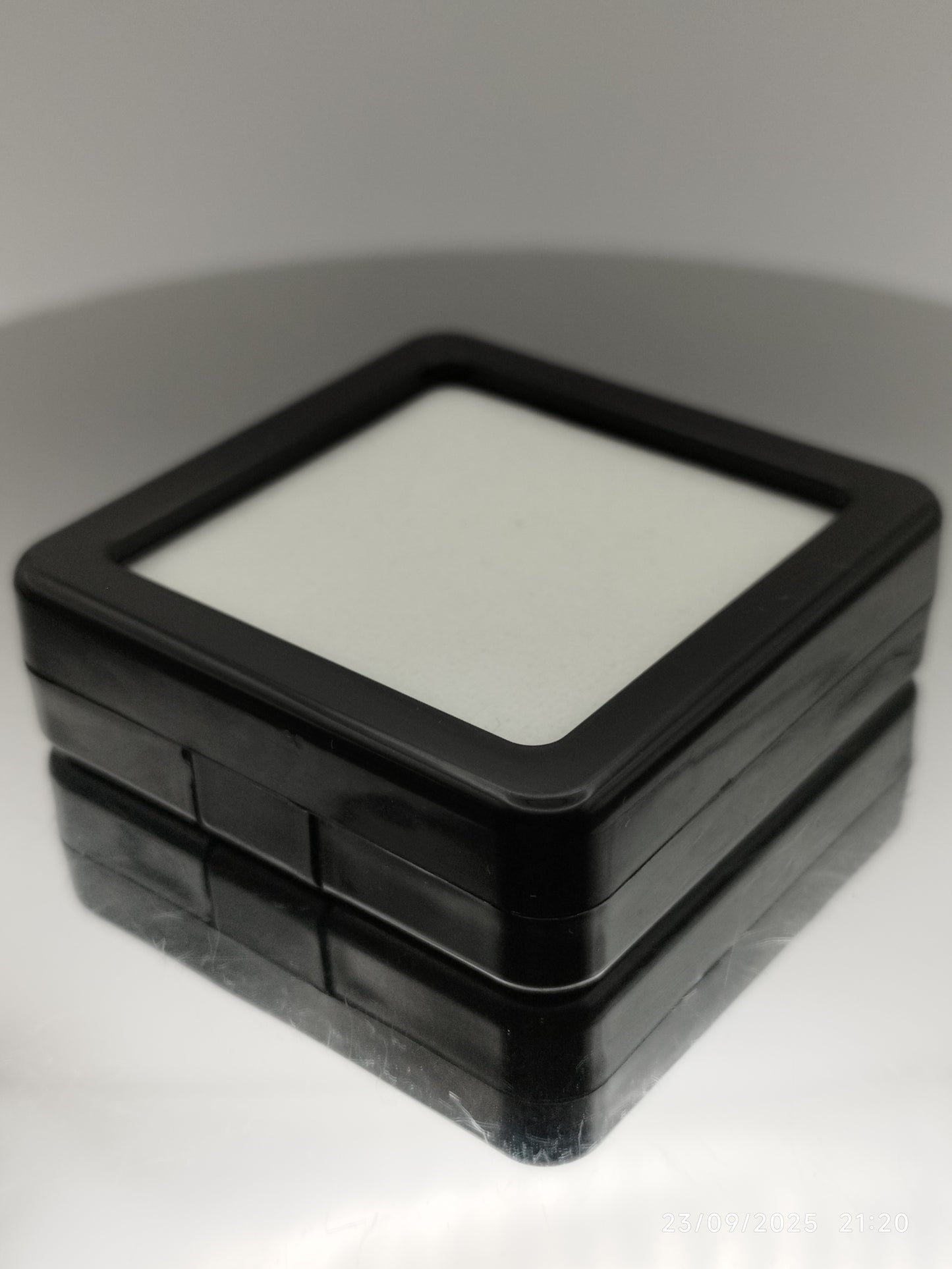 Black plastic box with window and white pad (5,4 * 5,4 * 1,6 cm)