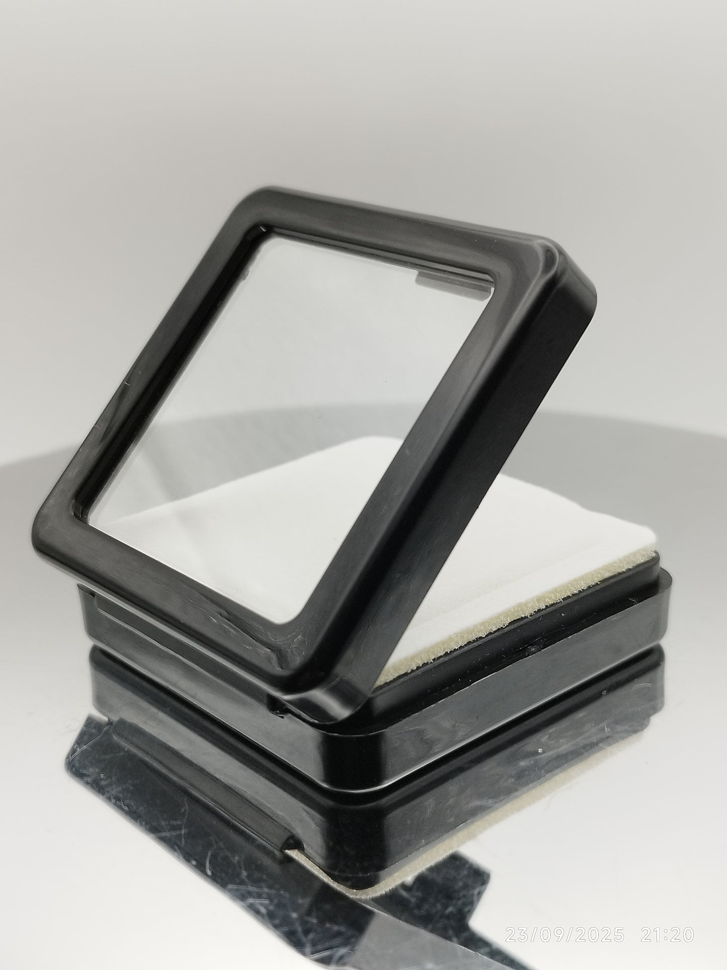 Black plastic box with window and white pad (5,4 * 5,4 * 1,6 cm)