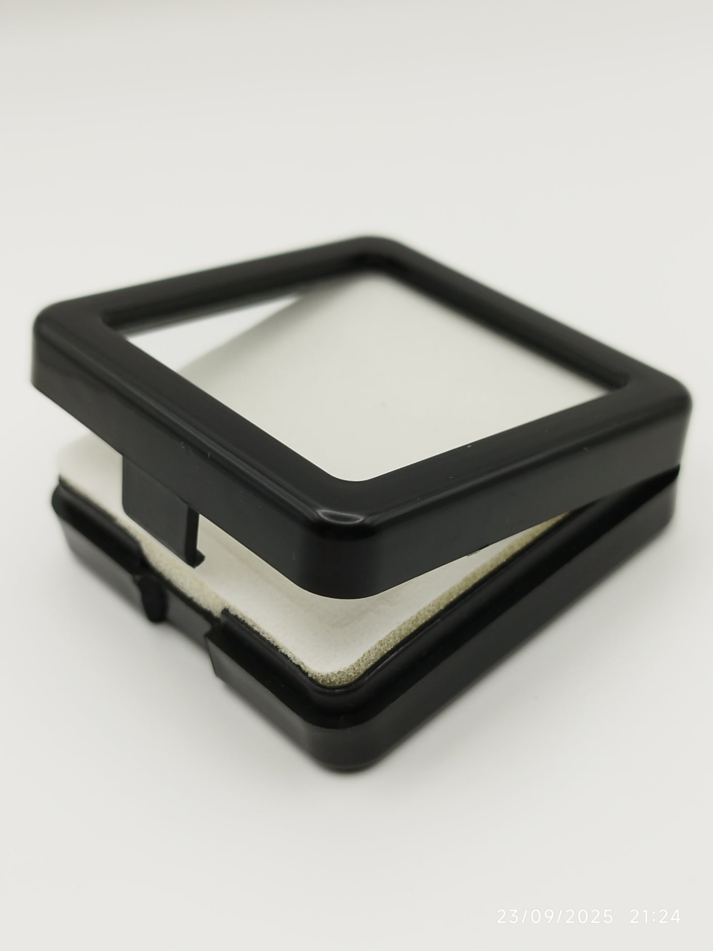 Black plastic box with window and white pad (5,4 * 5,4 * 1,6 cm)
