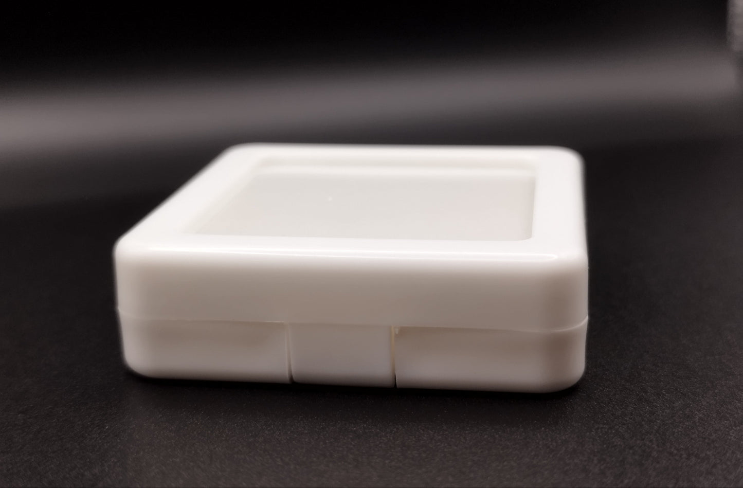 White plastic box with window and white pad (5,4 * 5,4 * 1,6 cm)