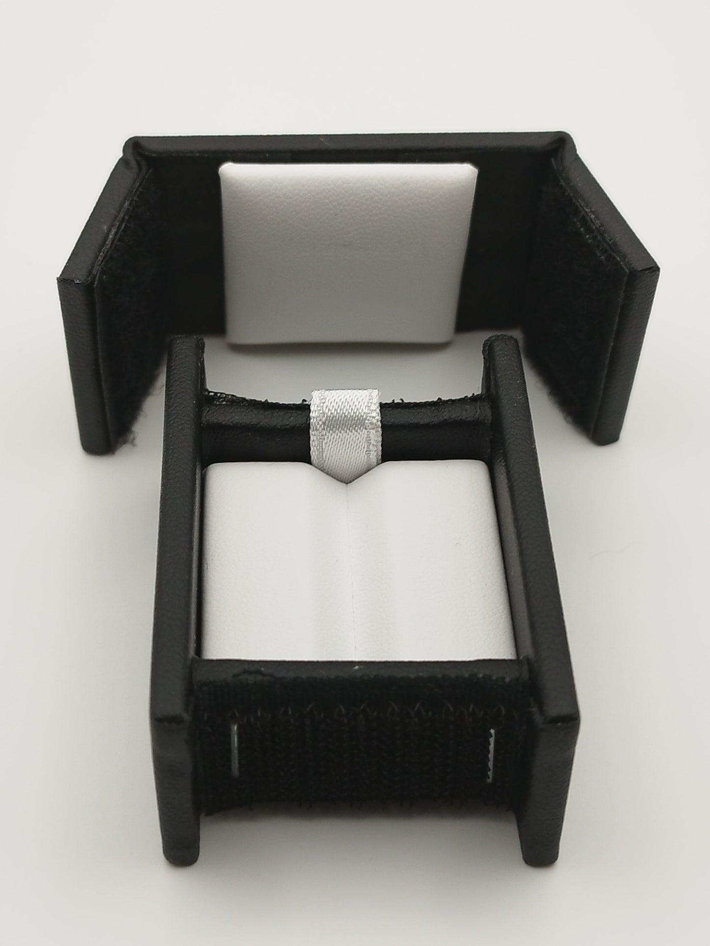 Rectangular leather-like black box with Velcro closure and white bifurcated pad (5,4 * 4 * 2,5 cm)