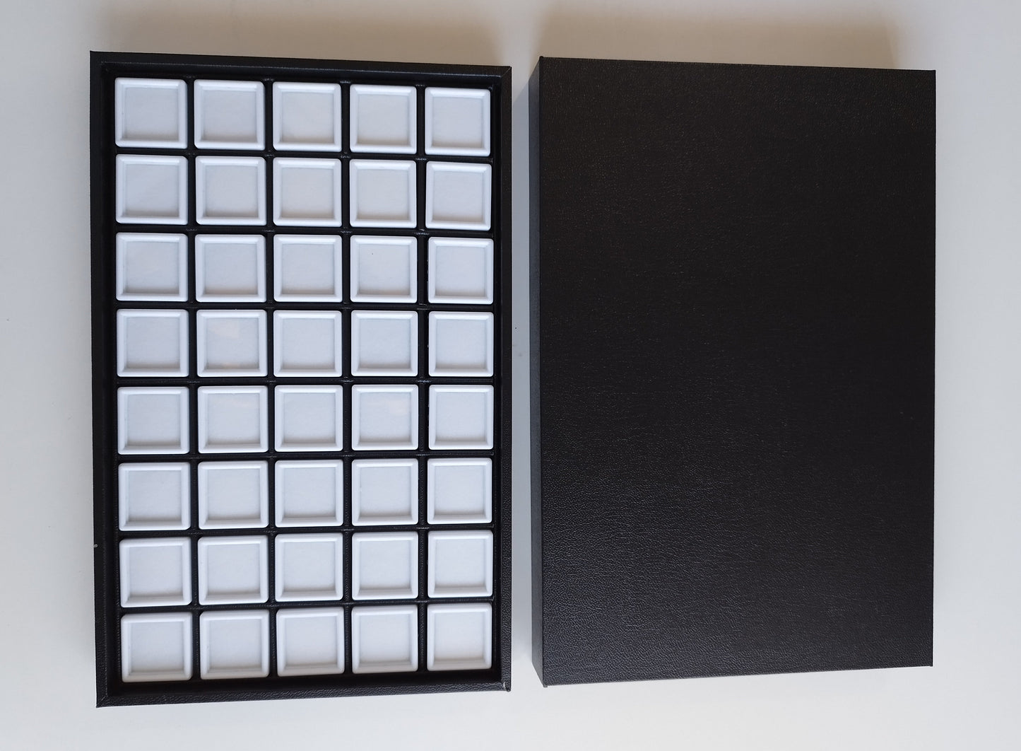 Black leather-style box with magnetic closure and sectioned interior. (28,5 * 19 * 3 cm)