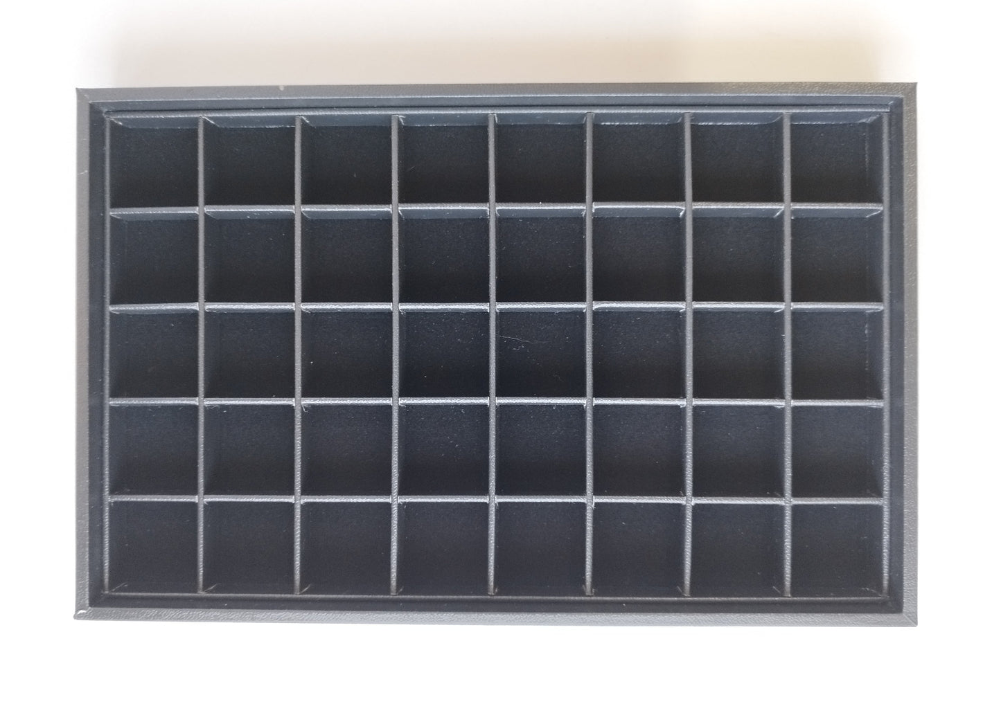 Black leather-style box with magnetic closure and sectioned interior. (28,5 * 19 * 3 cm)