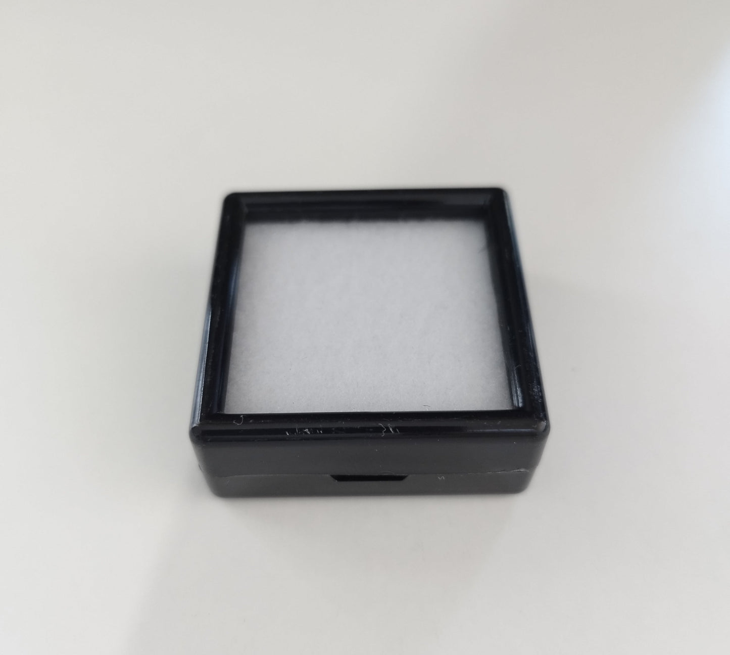 Black square plastic box with window and white pad (4 * 4 * 1,5 cm)