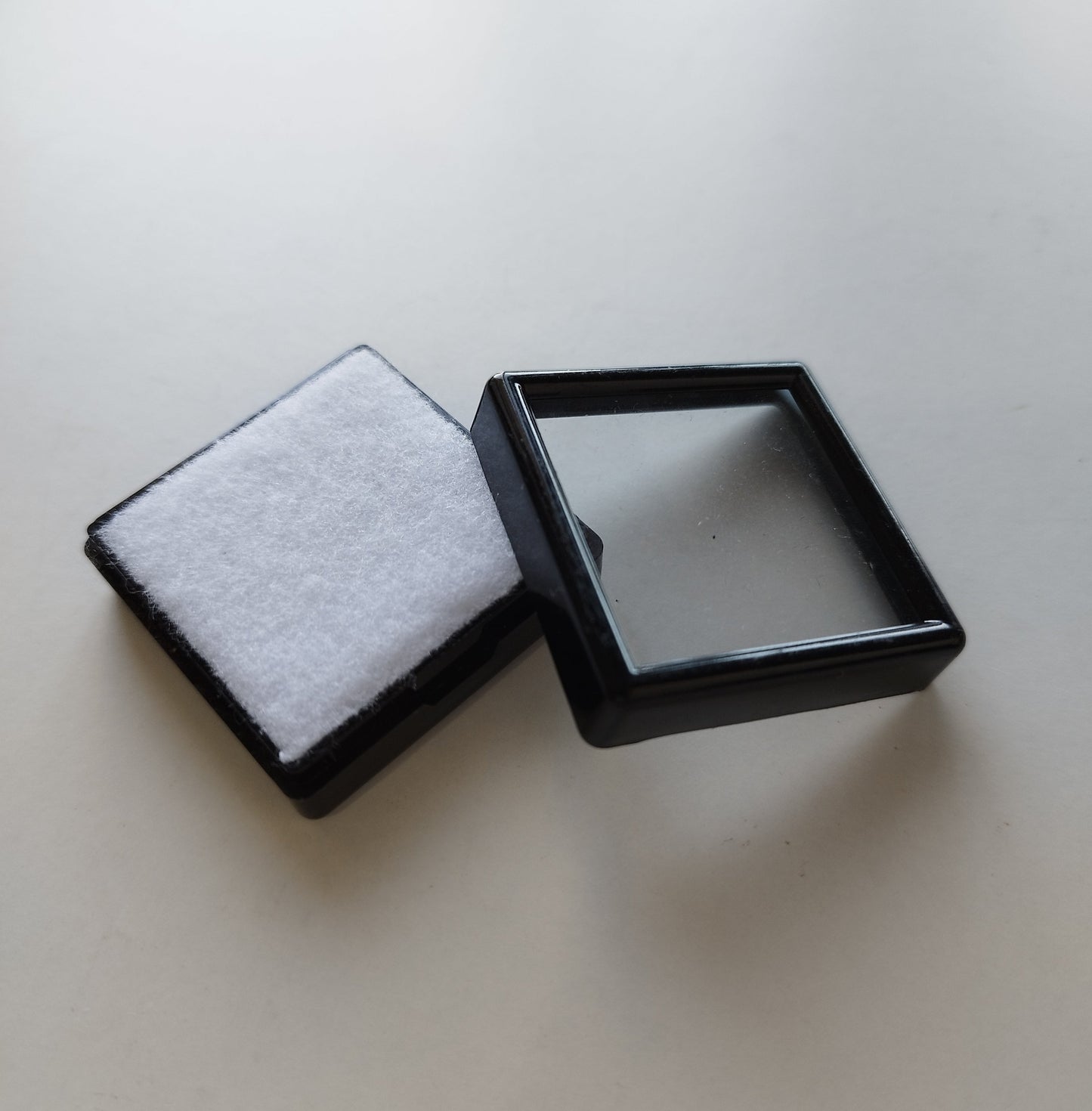 Black square plastic box with window and white pad (4 * 4 * 1,5 cm)