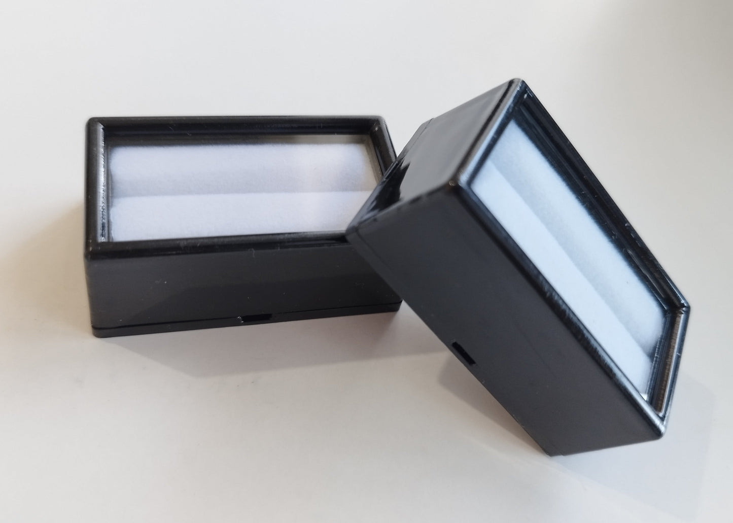 Black rectangular plastic box with white bifurcated pad and top window (5,2 * 2,8 * 2 cm)