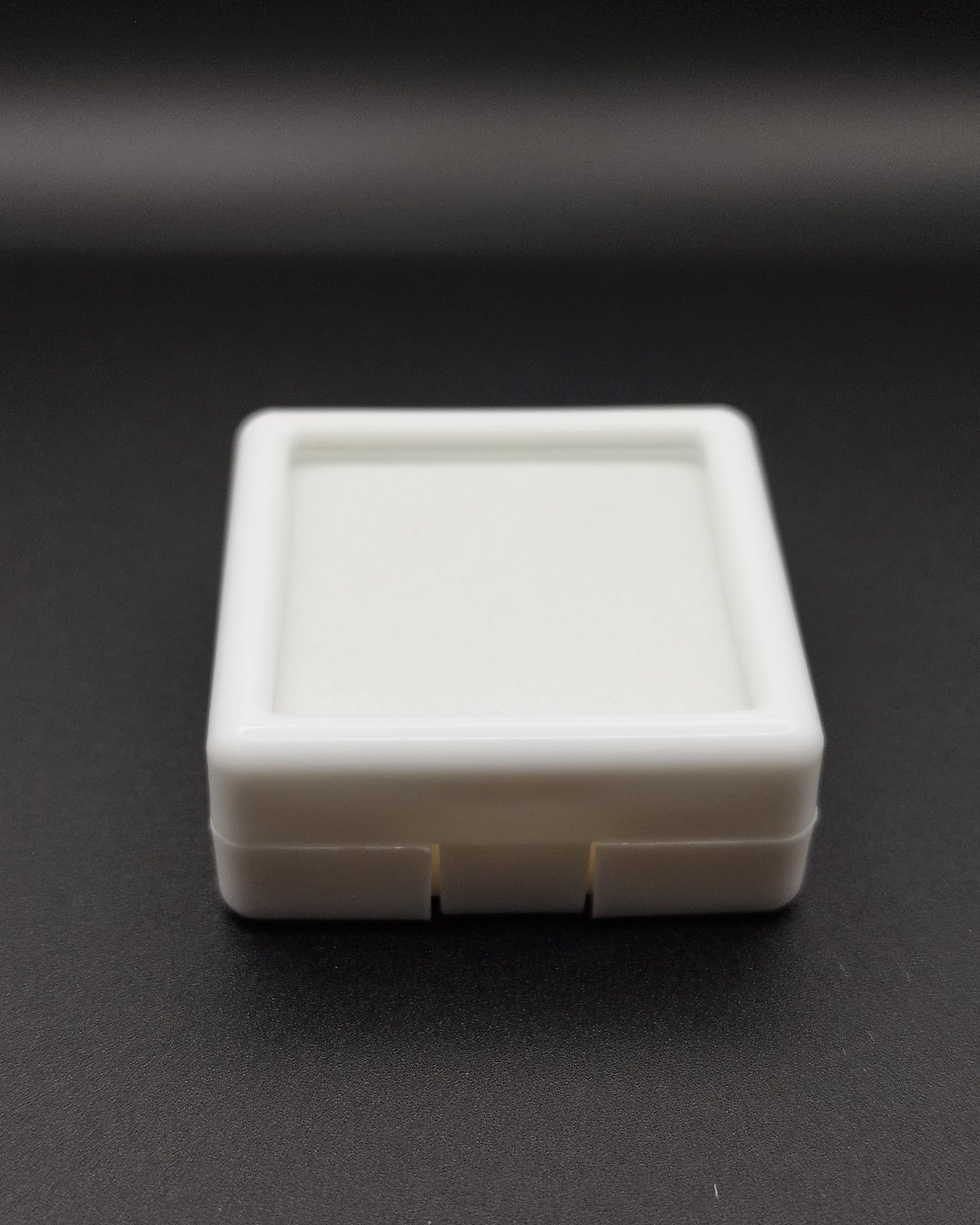 White plastic box with window and white pad (4 * 4 * 1,7 cm)