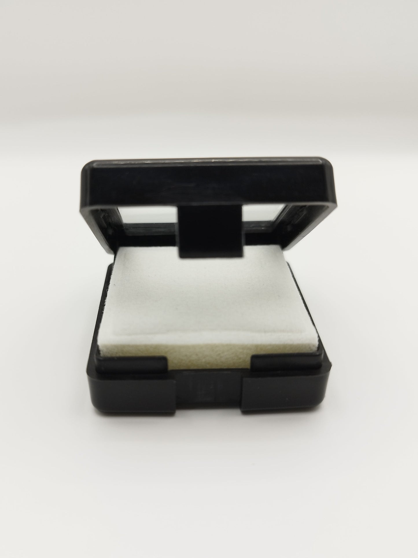 Black plastic box with window and white pad (4* 4 * 1,7 cm)